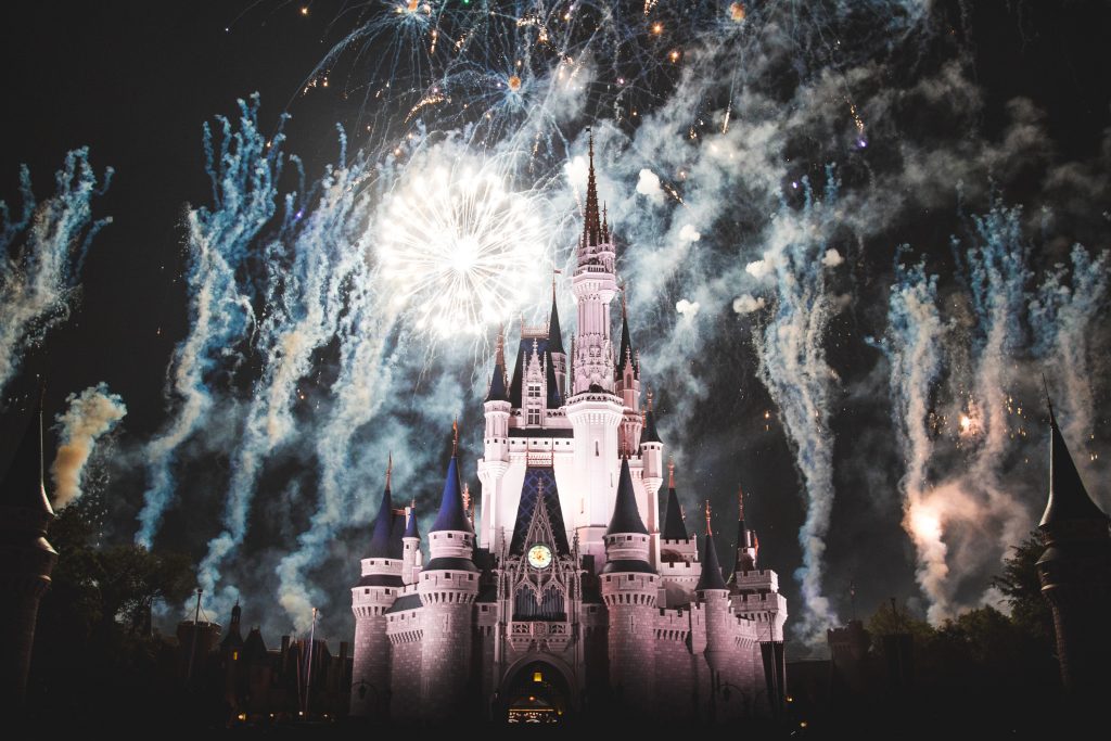 Dramatic night time view of castle at Disney World with fireworks exploding and smoke