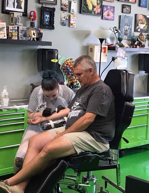 Photo of man getting a 54 tattoo in memorial