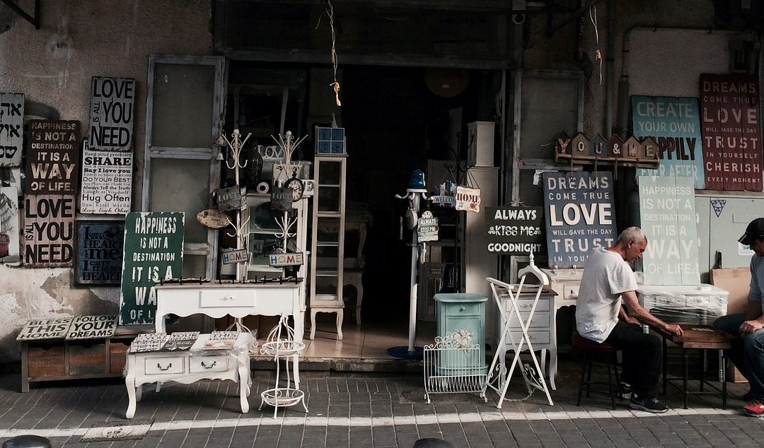 vintage signs and furniture at an old storefront. showing rust and aging